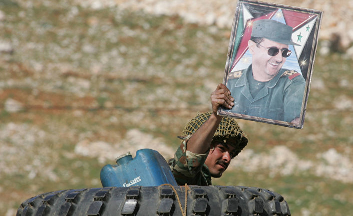 Сирийский солдат с плакатом президента Башара Аль-Асада